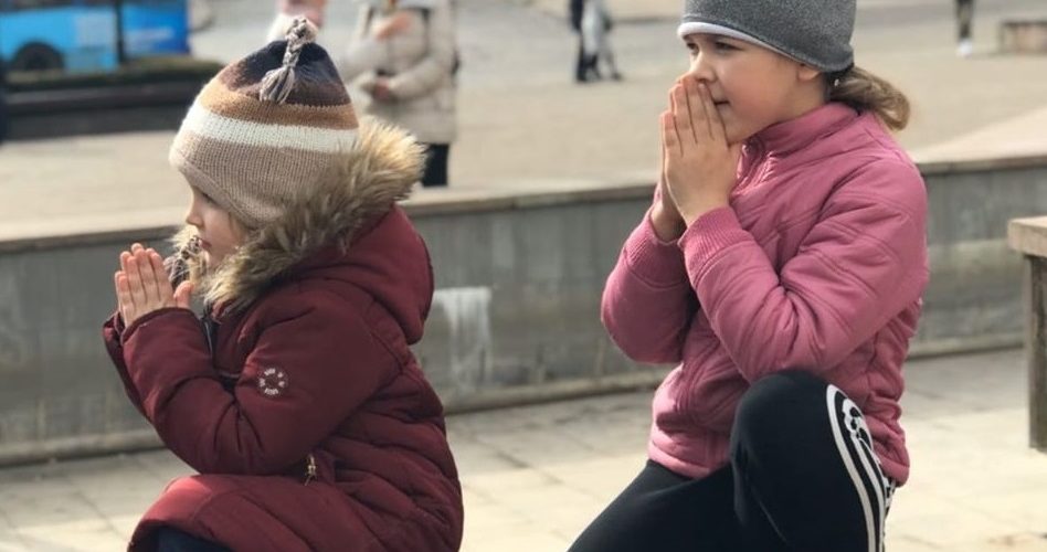 Ці двоє маленьких дівчаток гралися на площі... Але почувши молитву за Гeроєм – прибігли і, вклякнувши на колінця, почали молитися...